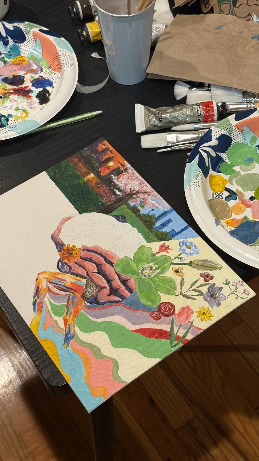 Colorful paintings, brushes, and palettes on a table.